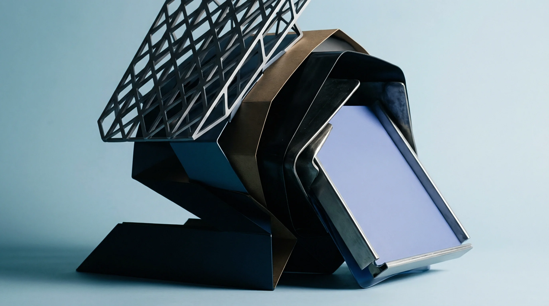 Folded metal panels and a mesh grid surround an angled electronic display module inside a controlled studio environment.