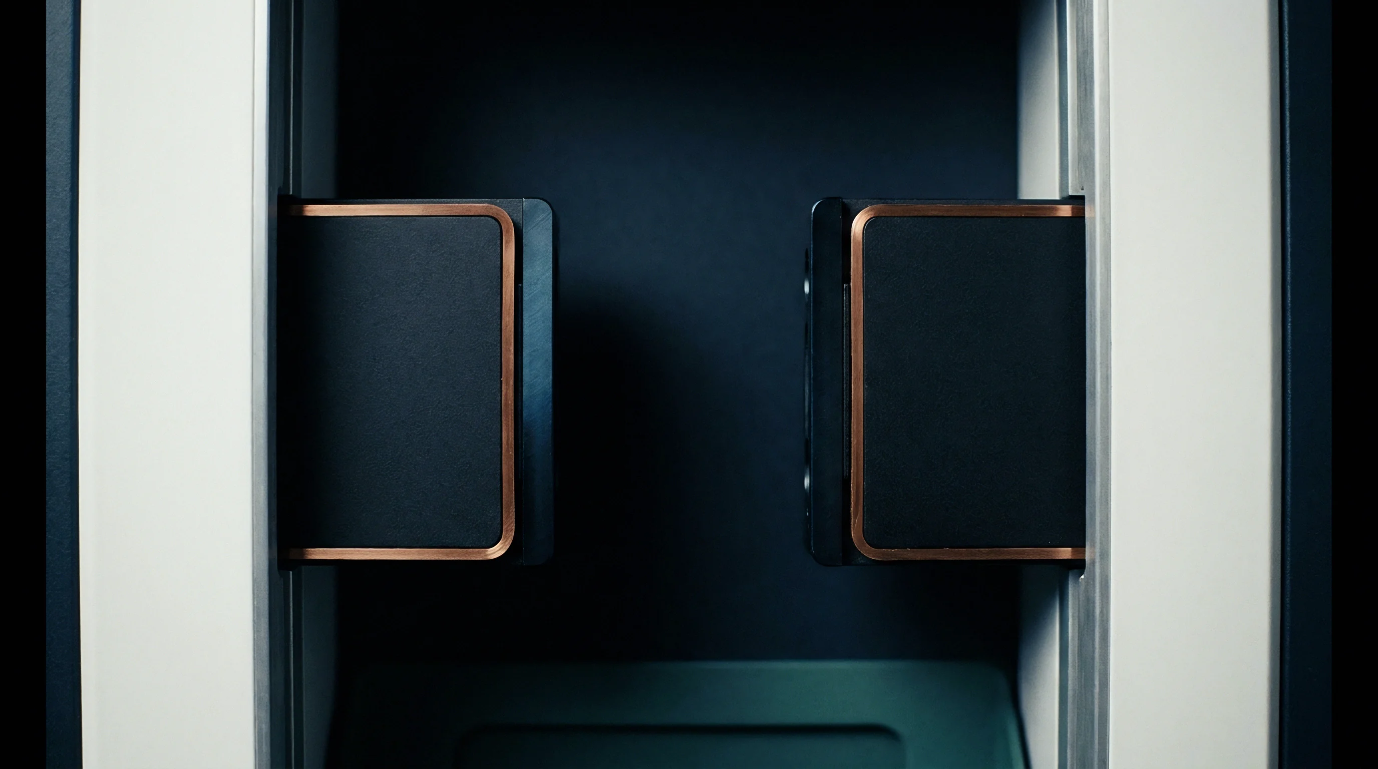 Two rectangular sensor modules with copper edges are mounted symmetrically on vertical aluminum rails within a dark matte enclosure for automated inspection.